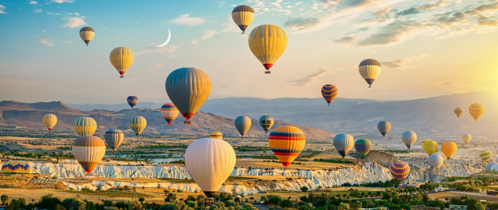 Globos aerostáticos volando sobre un paisaje de Capadocia al amanecer