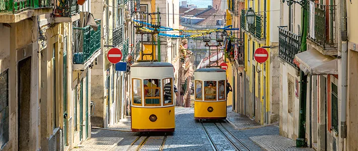 Tranvías amarillos circulando por una calle estrecha del Bairro Alto de Lisboa