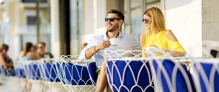 Pareja tomando un café en una terraza durante una escapada del puente de mayo.