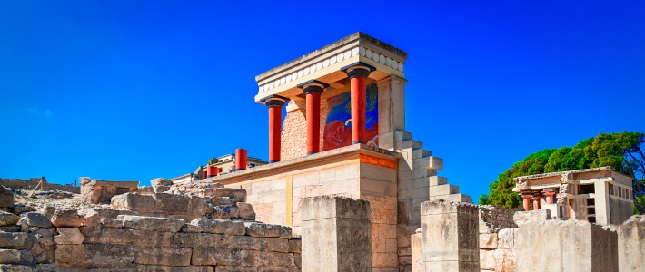 Ruinas del palacio de Cnosos con columnas rojas y muros de piedra en Creta