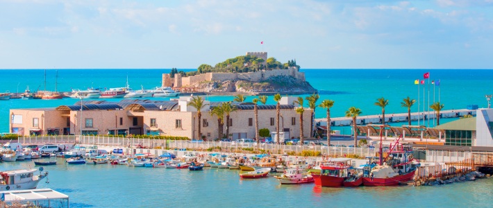 Puerto con barcos y fortaleza en una isla frente a la costa de Kusadasi