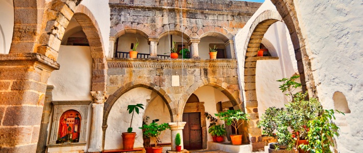 Patio central del Monasterio de San Juan el Teólogo en Patmos con arcos de piedra