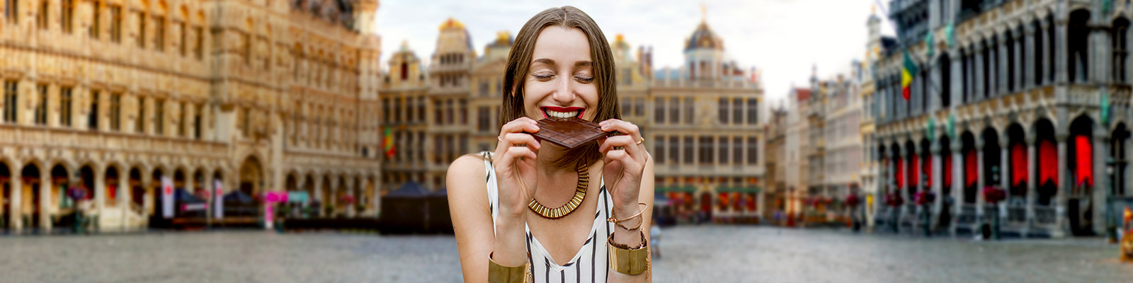 Chica comiendo chocolate en la Grand Place de Bruselas